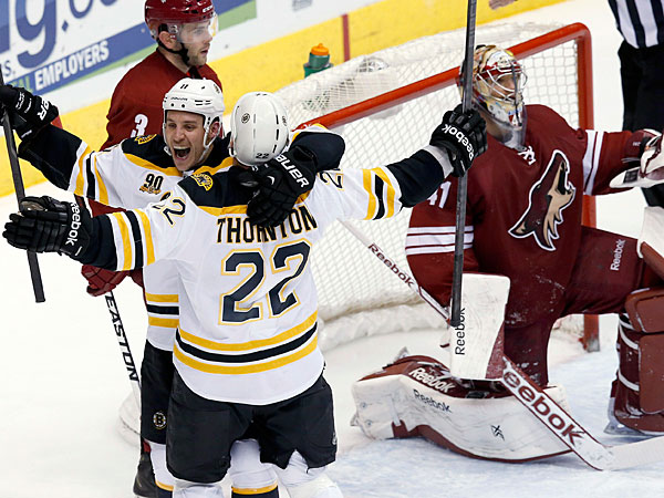 Bruins´ Shawn Thornton (22) celebrates his goal against Phoenix Coyotes´ Mike Smith, right, with teammate Gregory Campbell (11) as Coyotes´ Keith Yandle (3) skates past during the third period of an NHL hockey game Saturday, March 22, 2014, in Glendale, Ariz. The Bruins defeated the Coyotes 4-2. (Ross D. Franklin/AP)
