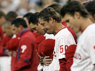 Philadelphia Phillies players pass along the casket of their long