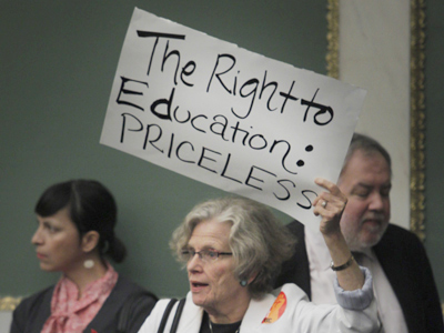 Shelly Yanoff with Public Citizens for Children and Youth holds a sign in support of education during a public hearing. (Alejandro A. Alvarez / Staff Photographer)