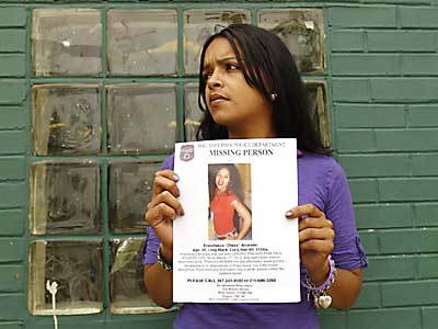 A woman referring to herself as "Mia," holds a missing person poster of  her younger sister Franchesa "Cheka" Alvardo at the Piccoli Park and City Recreation Center in the Juniata section of Philadelphia on Wednesday, May 30, 2012.  ( Yong Kim / Staff Photographer )