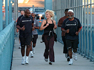 Anne Mahlum, founder of the non-profit Back On My Feet organization, runs up the Ben Franklin Bridge with a group during an early morning jog. ( Clem Murray / Staff Photographer )