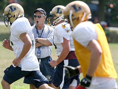 La Salle High School head coach Drew Gordon, center, watches his team run sprints. (Charles Fox / Staff Photographer)