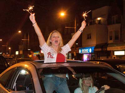Fans celebrate the Phillies' win on South Broad Street near Synder Avenue on Wednesday.  (John Costello / Staff Photographer)  