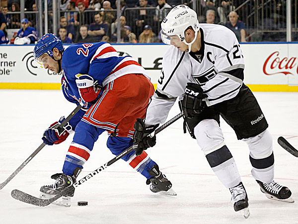 Kings right wing Dustin Brown tries to steal the puck from Rangers right wing Ryan Callahan. (Kathy Willens/AP)
