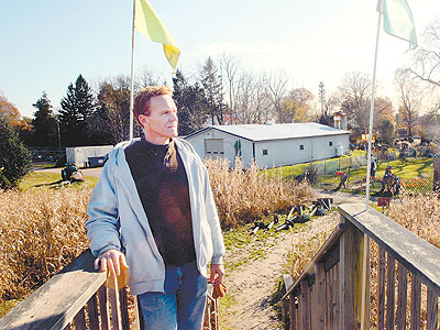 In Morrisville, Jonathan Snipes stands on the lookout bridge overlooking his family farm&acute;s corn maze. (April Saul / Staff Photographer)