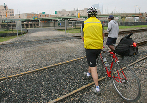 A cyclist and pedestrian take advantage of access to Schuylkill River Park over the CSX tracks at Locust Street. This informal path will become a more structured and safe walkway by the end of 2009.