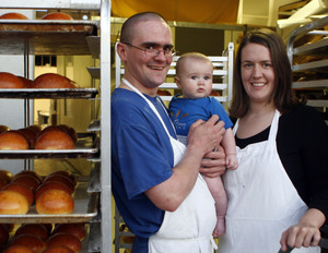Nishon Yaghoobian stands with his son , also Nishon, and wife Laura Yaghoobian near trays of their fresh-baked breads and rolls. Their Wild Flour Bakery caters to the yeasty needs of Philadelphia's best restaurants.