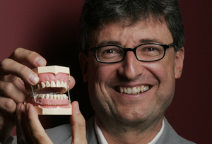 Small Bite Inc. CEO Denis Mulder displays his company's device, which is designed to help people lose weight by making them take smaller bites, ultimately reducing the amount of food they eat. The Haverford company hopes to start patient clinical trials in Philadelphia early next year.