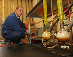 After tire pieces are microwaved, gas is pumped out through condensers and oil is collected. Jay Gill monitors the progress.