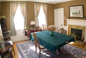 The dining room of Sarah Graves' 1823 home is furnished with secondhand finds and painted a color she calls "dark toast."
