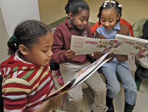 Junior Girl Scout Ruby DeMaio (left), reads the new cookie order forms with Brownies Caitlin Goodman and Anyae Jones at The Triumph Baptist Church in Philadelphia.