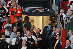 Former Flyers goalie Ron Hextall (center, in suit) watches a highlight reel of his career along with fans before being honored with induction into the Flyers Hall of Fame last night.