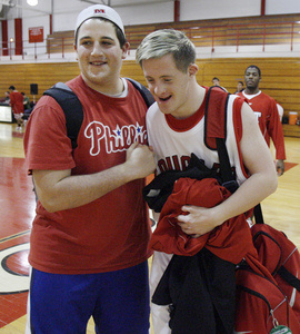 Brad Hennefer is congratulated by friend Eric Einbinder (left) after Cherry Hill East's basketball game against Pennsauken.