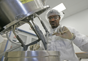 Jarvis Mattison, a technician at the W.C. Heraeus GmbH & Co. facility in Conshohocken, scrapes the blades of a mixer used in making bonding paste.