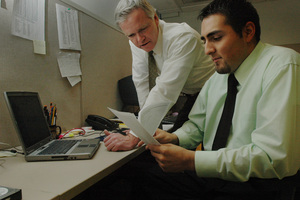 Detective Sgt. Joseph A. Ryan (left) and Martin Morfin, a senior accounting major at Villanova, review embezzling case data.