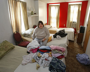 Victoria Walos, 47, unpacks clothing that she will put away in a dresser at her new residence, Wilson's Personal Care Home, after leaving Cambridge Retirement Community, which is closing.