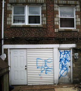 Threatening graffiti tags the house of Scott Schweizer, on Gilham Street near Sackett in the Northeast.