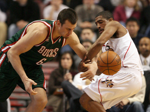 Kevin Ollie, fouling Bucks' Andrew Bogut in January, has become a mentor to young Sixers.