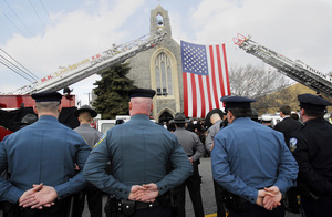 Police officers and firefighters wait outside Holy Saviour Church in Lower Chichester during the funeral of Firefighter Nicholas Picozzi II. Picozzi died after being pulled from a burning building in Upper Chichester on March 5.