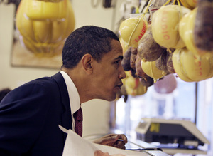 Barack Obama leans over the counter at Claudio Specialty Foods shop during a campaign stop in the Italian Market yesterday.