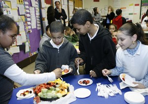 Fourth-graders serve themselves fresh fruit during a nutrition exercise last week at Fairhill School in North Philadelphia. From left: Gabrielle Hudnell, Erick Ramirez, David Barroso and Asle Torres.