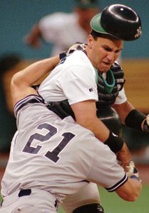 John Marzano , then with the Mariners, battles the Yankees' Paul O'Neill (21) at the plate after the two had exchanged words over a brush-back pitch.