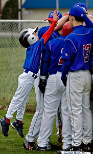Washington Township bat boy Ryan Swift, 8, brother of Minutemen pitcher Rob Swift, tries to join the pregame huddle.