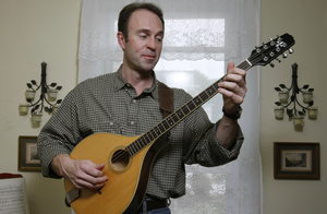 Charlie Zahm plays a bouzouki at his Coatesville home. Since he was a youngster, he has been taken by bluegrass and folk music. "I love the traditional aspect of folk songs," Zahm says. "The stories are timeless - songs of love, loss, exploration and adventure."