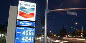 Cars pass a Chevron station showing high gas prices in Palo Alto, Calif., on Thursday. Chevron reported that profits jumped more than 9 percent in the first quarter.