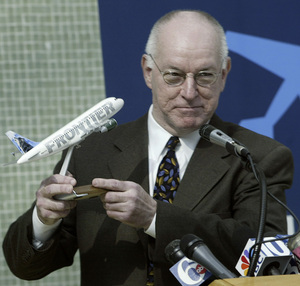 Charles Isdell , acting aviation chief, holds a model plane given to him by Frontier Airlines.