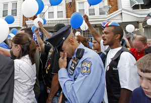 Officer Samuel Cruz pauses as balloons are released yesterday to celebrate what would have been the 40th birthday of slain Police Sgt. Stephen Liczbinski, at his memorial site in Port Richmond.