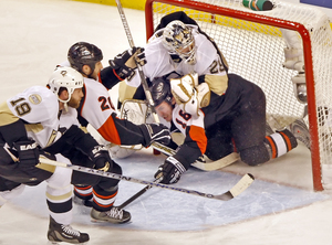 Flyers forward Mike Richards slides into Marc-Andre Fleury's net during a second-period rush.