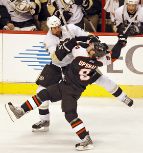 Flyers' Scottie Upshall checks Hal Gill, a member of the Penguins' strong defense.