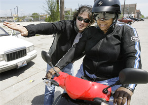 Marnetta Porter gets a crash course on scooter-driving from Johnny Scheff of Motoworks in Chicago after buying a Vespa Tuesday. Scheff said scooters could pay for themselves in fuel savings in one to three years.