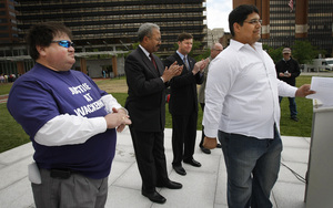 Charlie Wilson (left) and fellow Wackenhut employee Alberto Zerpa (right), of Miami, join U.S. Reps. Chaka Fattah (second from left) and Patrick Murphy (third from left) at news conference.