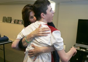 Steven Domalewski, who is severely disabled, is hugged by his mother. The family is suing over injuries he suffered from a line drive off an aluminum bat in a youth baseball game in 2006.