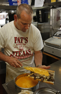 One cheesesteak palace where Whiz is the indisputable ruler is Pat's King of Steaks. General manager Tom Francano slathers a generous coating of it on a sandwich under construction.
