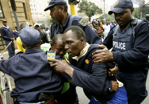 South African police detain a man during a protest march in Johannesburg. The latest disturbances have left at least 42 people dead and more than 25,000 foreigners displaced.