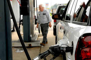 Steve Lankin, 68, whose Getty station survived the riot, waits on a customer. The Monday after the weekend protest, hundreds of cars lined up at his pumps.