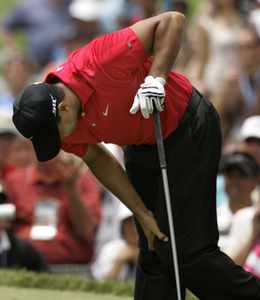 Tiger Woods holds onto injured left knee during fourth round of U.S. Open on Sunday.