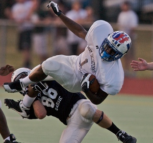 White's Askia Jahad of Willingboro is knocked down by Blue's Joe Henry of Shawnee. Jahad rushed for the White team's third touchdown of the night in the win.