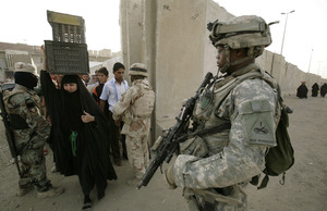 A U.S. soldier secures a checkpoint at a wall separating north and south Sadr City. Rows of walls divide the capital into smaller, more controllable areas.