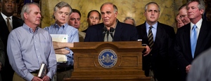 Accompanied by state lawmakers in Harrisburg, Gov. Rendell (center) discusses yesterday's agreement on the state budget that averted possible furloughs of thousands of state workers.