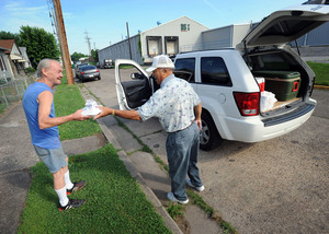 Meals on Wheels' Matt Jackson (right) delivers food in Charleston, W.Va. The group is losing volunteers due to gasoline prices.