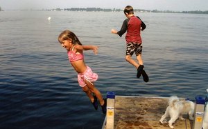 Abby, 6, and Alex, 9, jump into Lake Champlain from a Cozy Cottages dock.