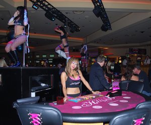 Francesca waits for blackjack players as dancers gyrate at the new Hell's Belles pit at the Hard Rock Casino.