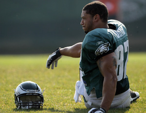 L.J. Smith stretches while sitting on the sidelines.