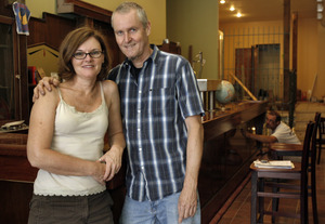 Owners Tom Baker and wife Peggy Zwerver at their new restaurant still under construction, Earth Bread + Brewery in Mount Airy. Carpenter Barry Homiak, right, works on the bar.