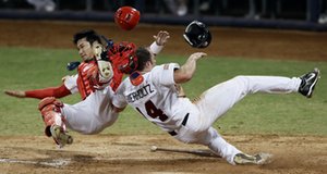 U.S. baseball player Nate Schierholtz collides with China's Wang Wei in the sixth. The catcher, who left the game, did not have the ball during the play.