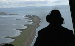 John Ferrari looks out of a Coast Guard C-130, surveying the coast near Kivalina . Part of the job is checking for erosion.